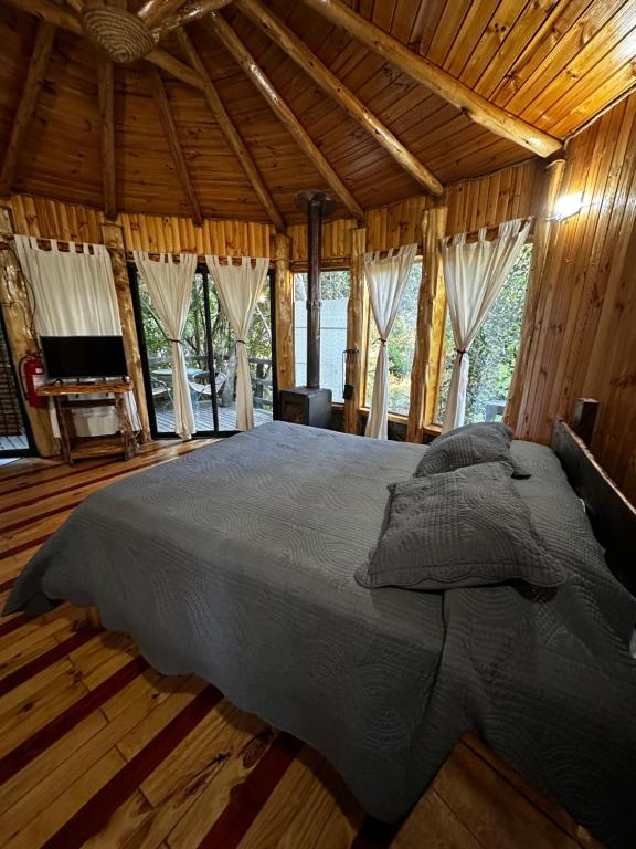 a bedroom with a large bed in a wooden house at Reserva los Bollenes in Constitución