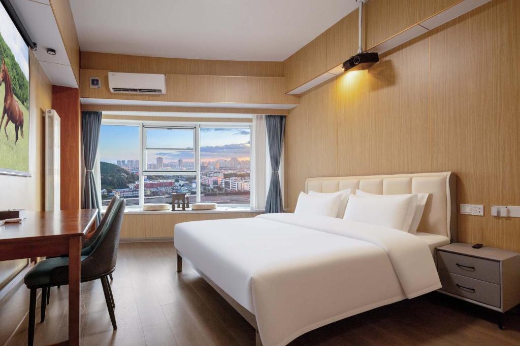 泰安市にあるWonderful Beginningの白いベッドと机と窓のある寝室