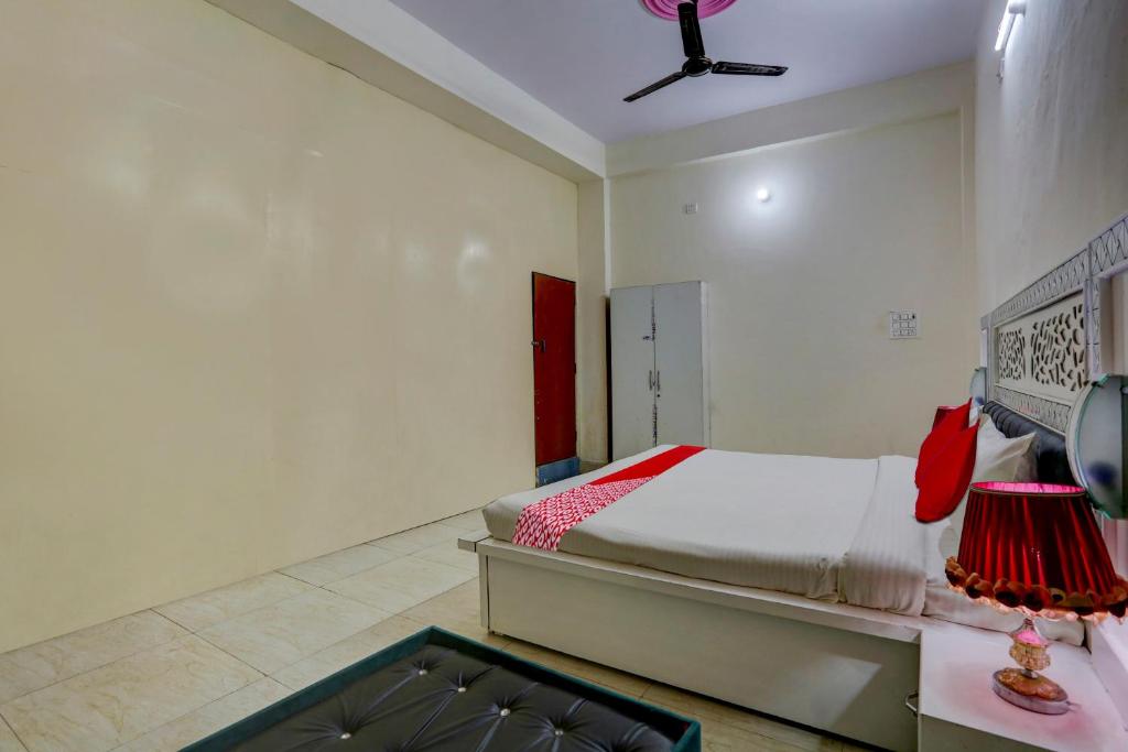 Un dormitorio con una cama y un ventilador de techo. en OYO 90856 HOTEL MANNAT, en Aligarh