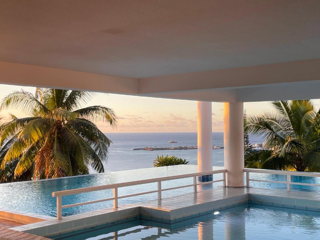 a swimming pool with a view of the ocean at Cozy du Grand Large in Papeete