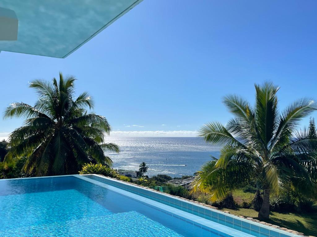 a swimming pool with a view of the ocean at Cozy du Grand Large in Papeete