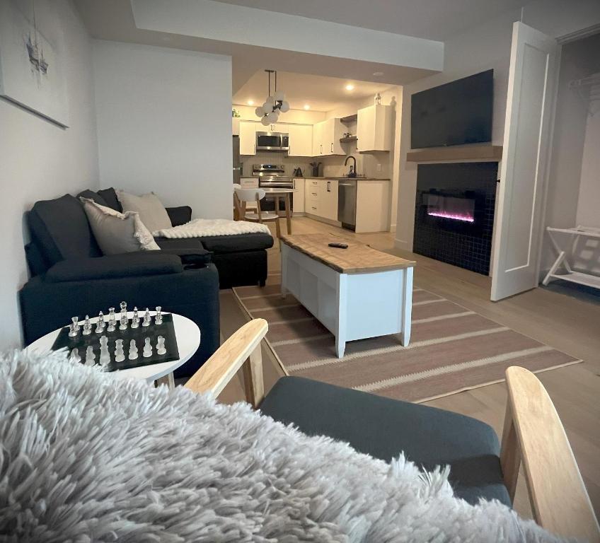 a living room with a blue couch and a table at Cedar & Sage Suite, Cozy Kitchen Comfort in Victoria