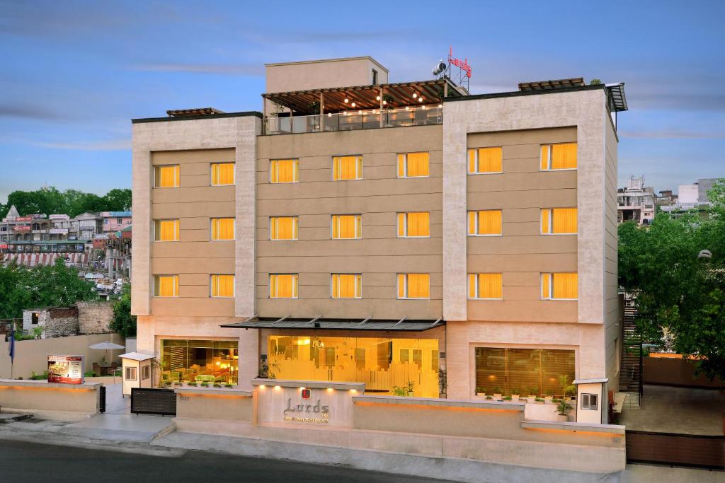 un edificio alto con luces en las ventanas en Grand Plaza Lords Inn Jammu, en Jammu