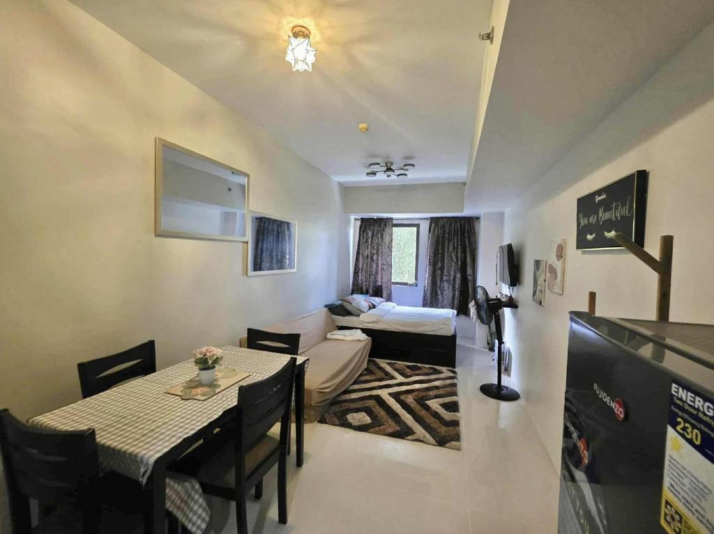 Una sala de estar con una mesa y una sala de estar con un sofá. en Comfort Homey Studio with Fresh Mountain Air by Cherisia's Hideaway, en Baguio