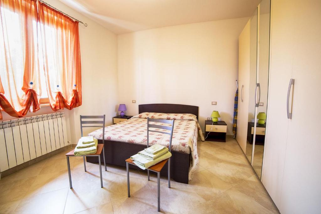 カスティリオーネ・デル・ラーゴにあるLa Carraiaのベッドルーム1室(ベッド1台、椅子2脚付)