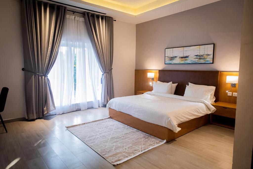 a bedroom with a bed and a large window at Central Residence by Paramount Hospitality in Karachi