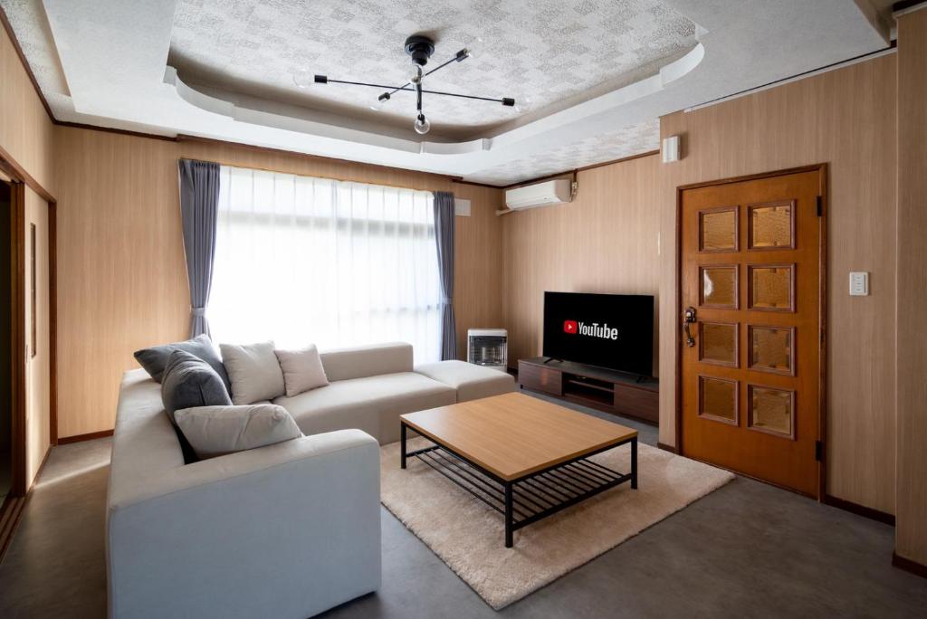 a living room with a couch and a table at Kamifurano House in Kami-furano
