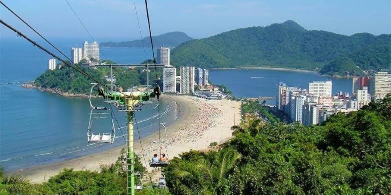 a gondola ride over a beach with a city at Pousada Duda Lins in São Vicente