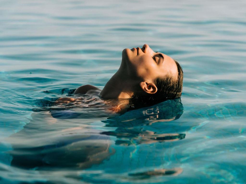 a man floating in the water with his eyes at Mercure Aix-les-Bains Domaine de Marlioz Hôtel & Spa in Aix-les-Bains