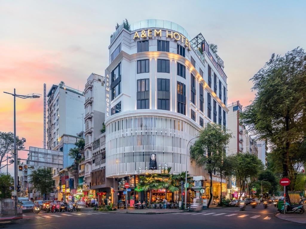 un grand bâtiment blanc avec une enseigne dessus dans l'établissement A&EM Saigon Hotel, à Hô-Chi-Minh-Ville