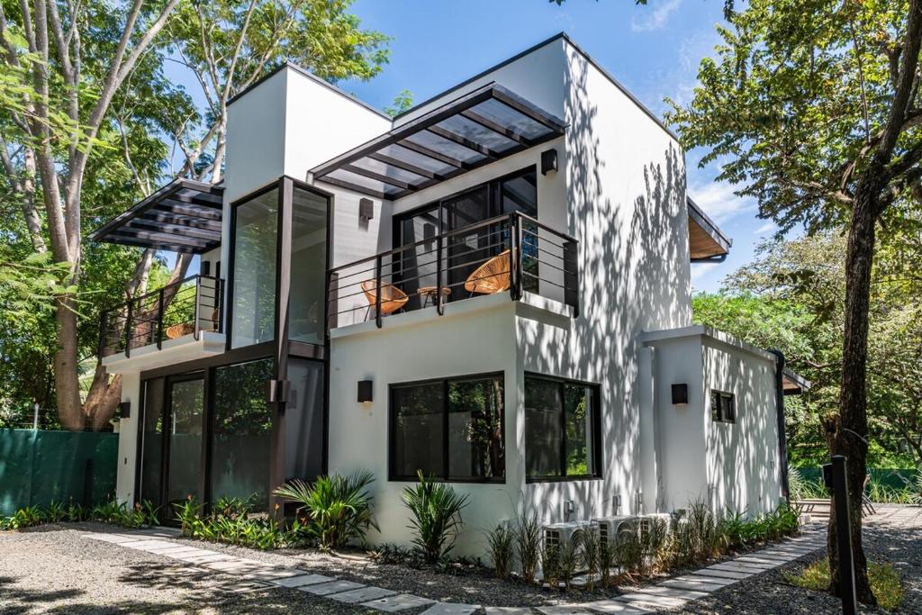 ein weißes Haus mit einer schwarz-weißen Fassade in der Unterkunft Luxury villa walking distance to Playa Grande in Refundores