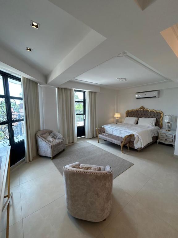 a large bedroom with a bed and a couch at La Gabbanee Hotel Boutique in Fernando de la Mora