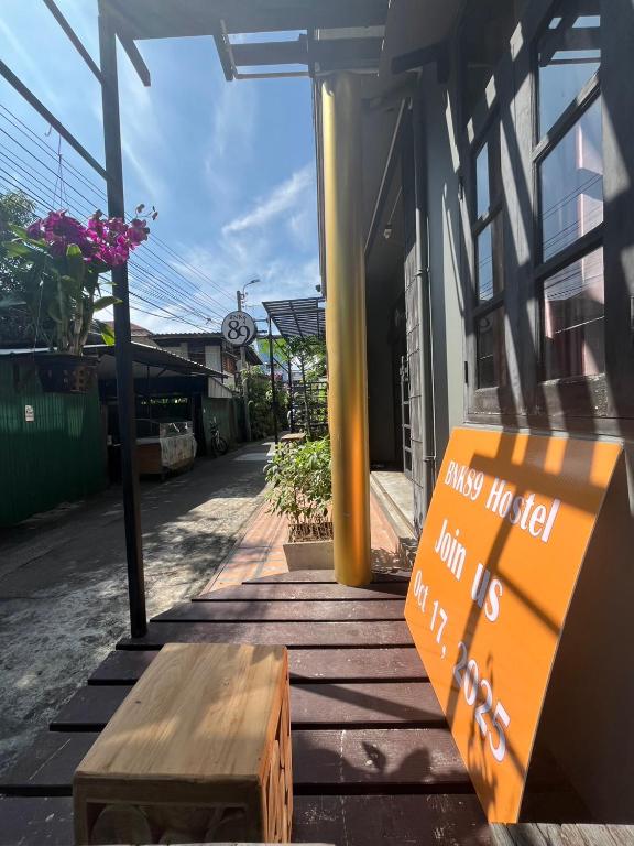 a bench and a sign in front of a building at BNK89 Hostel in Bangkok