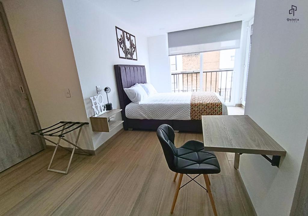 a bedroom with a bed and a table and a chair at Quinta Park 43 in Bogotá