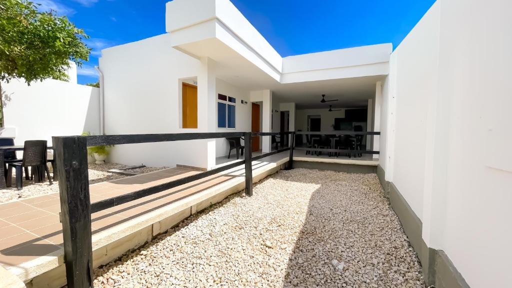 a white house with a fence and a patio at Habitacion Manglares 101 in Coveñas