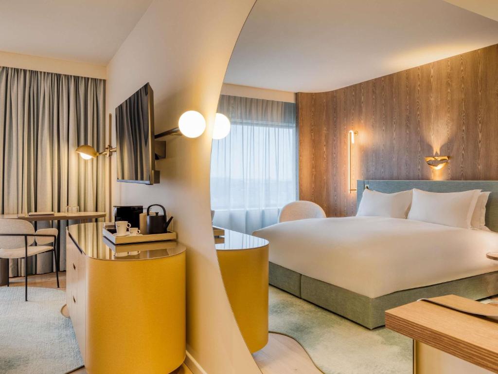 a hotel room with a bed and a desk at Mövenpick hotel Brussels airport in Zaventem
