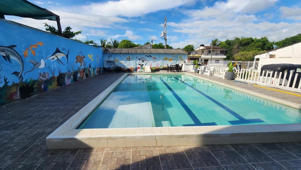 a swimming pool with a mural on the side of a building at Cabaña brisa de mar in San Silvestre