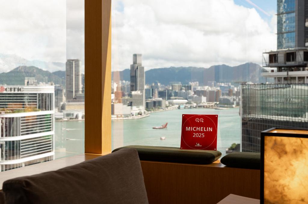a book sitting on top of a window with a view of a city at Upper House Hong Kong in Hong Kong