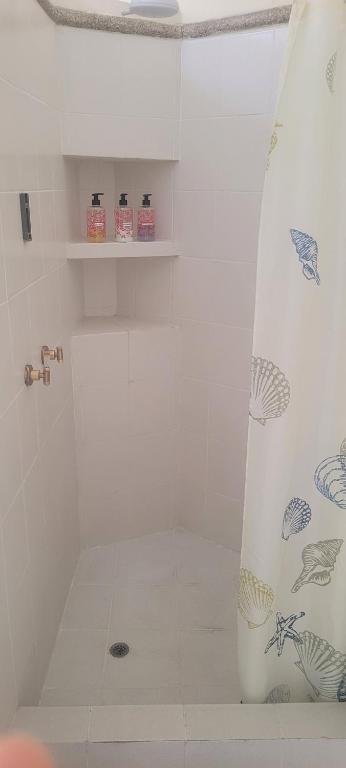 La salle de bains est pourvue d'une douche blanche avec rideau de douche. dans l'établissement Suite Samborondón, à SamborondÃ³n