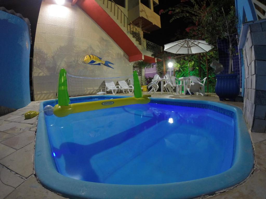 
a swimming pool with a blue tub and a blue chair at Pousada La Puerta Del Sol in Porto De Galinhas
