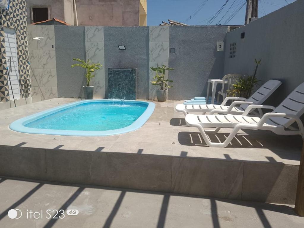a swimming pool with lounge chairs and a swimming pool at Casa com piscina e área gourmet em Arembepe in Camaçari