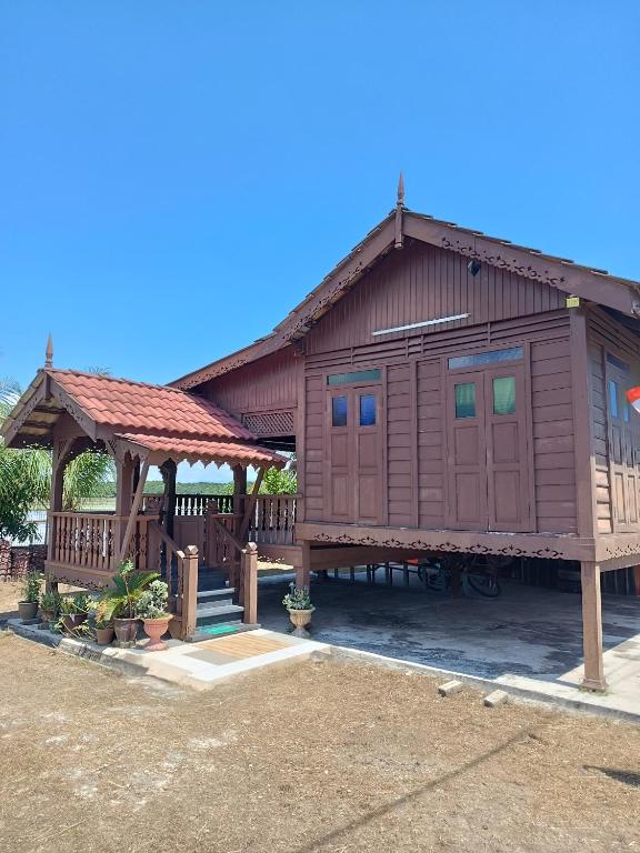 Cabaña de madera con porche y cenador en Rumah Kayu Homestay, en Bedung