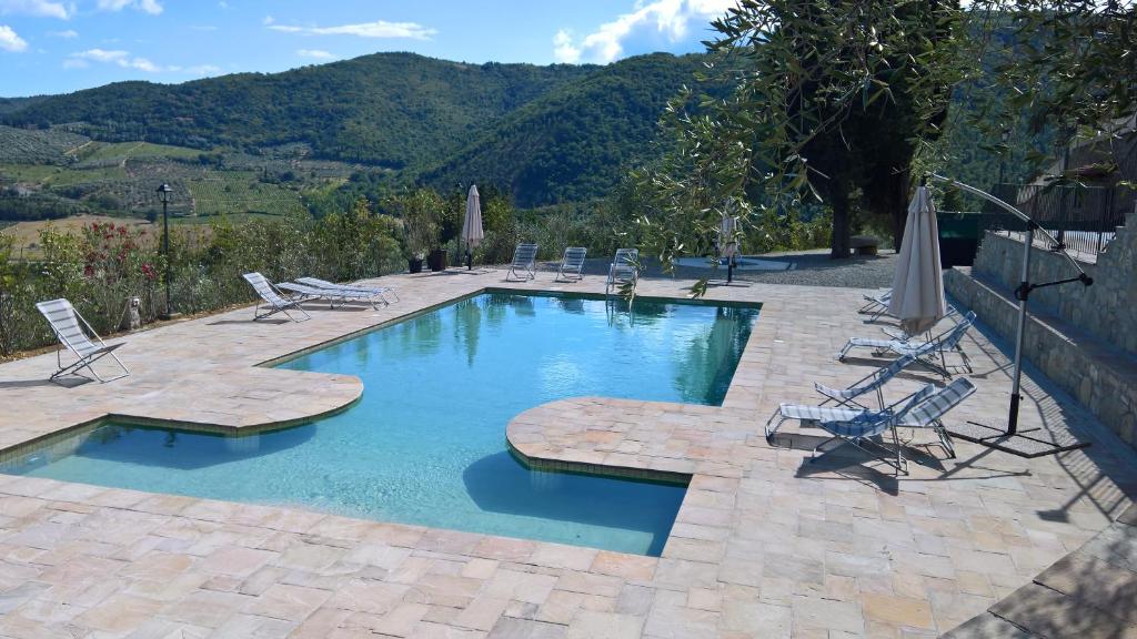 a swimming pool with lounge chairs at Villa D'Arte Agri Resort in Pontassieve