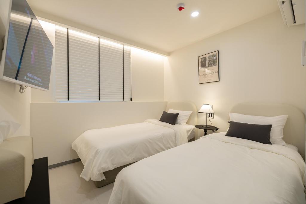 um quarto com duas camas e uma TV em MOREN Seoul Myeongdong em Seul
