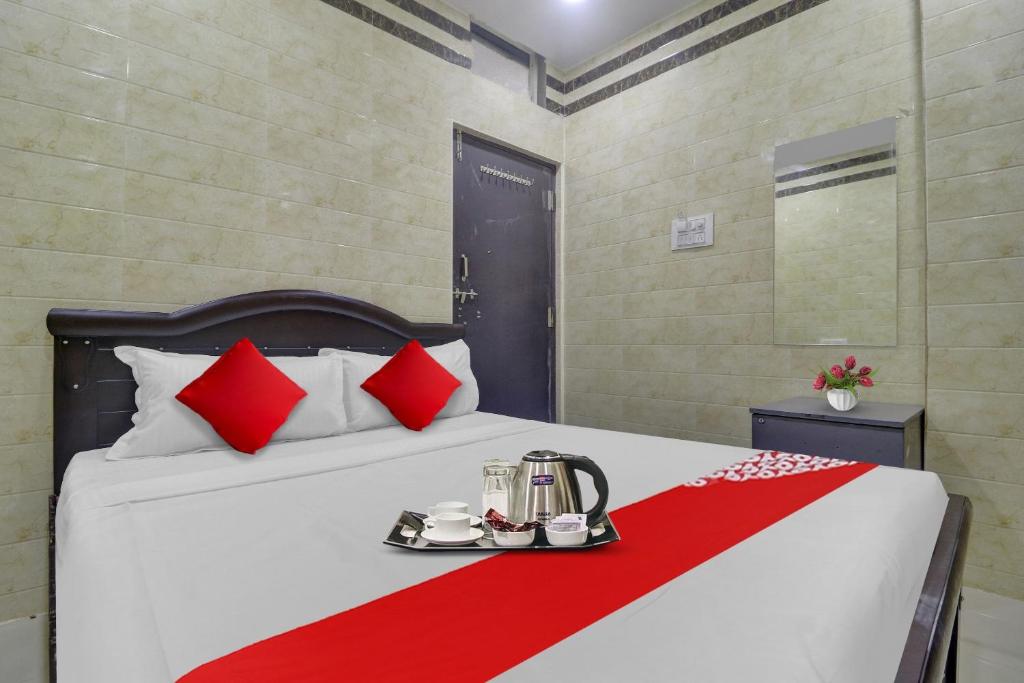 a hotel room with a bed with red and white pillows at Super Hotel O Ashoka Classic Near Gokul Chat in Hyderabad