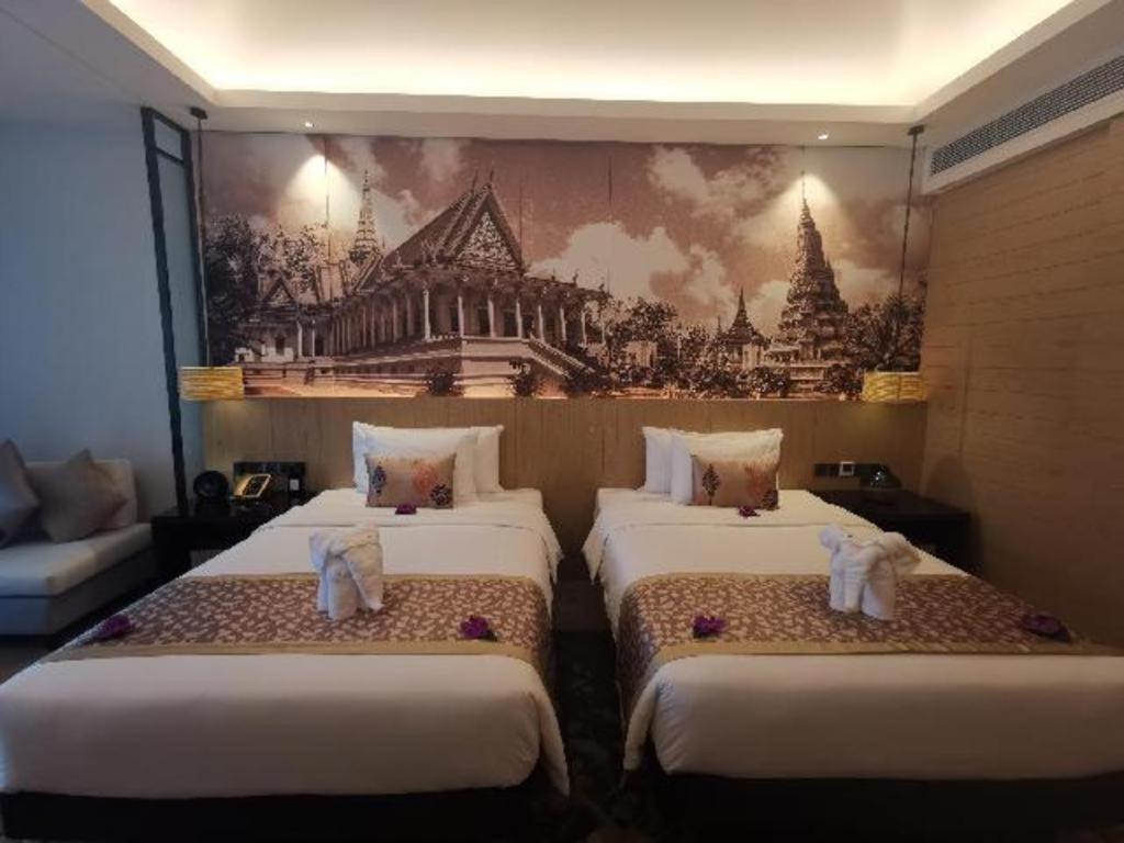 シアヌークビルにあるNanhai International Hotelの壁画のある部屋のベッド3台