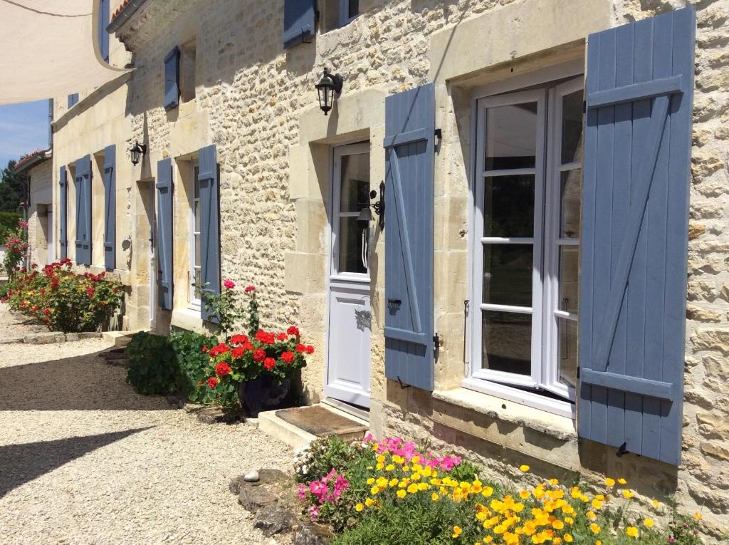 een rij huizen met blauwe luiken en bloemen bij Le Clos du Plantis in Sonnac