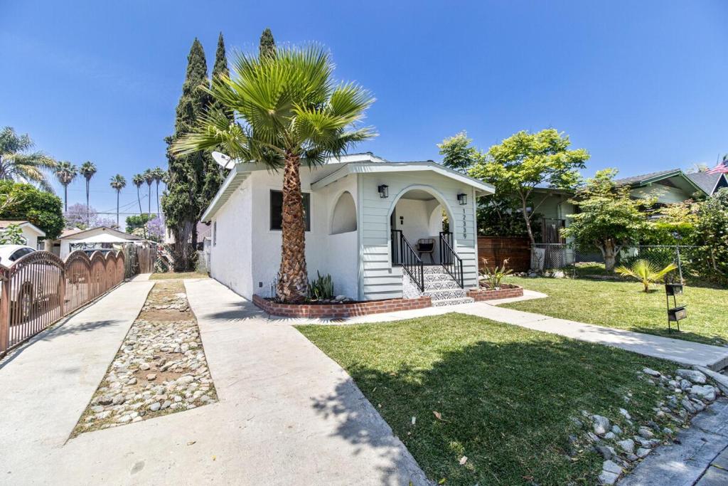 a white house with a palm tree in a yard at Mi Casita-Bungalow Vacation Home in Whittier