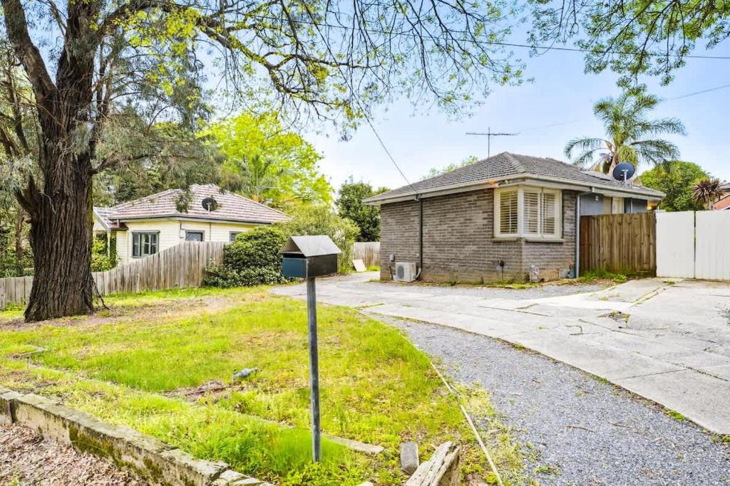 a house with a parking meter in the yard at Comfy Croydon Family Getaway Near Trails and Cafes in Ringwood North