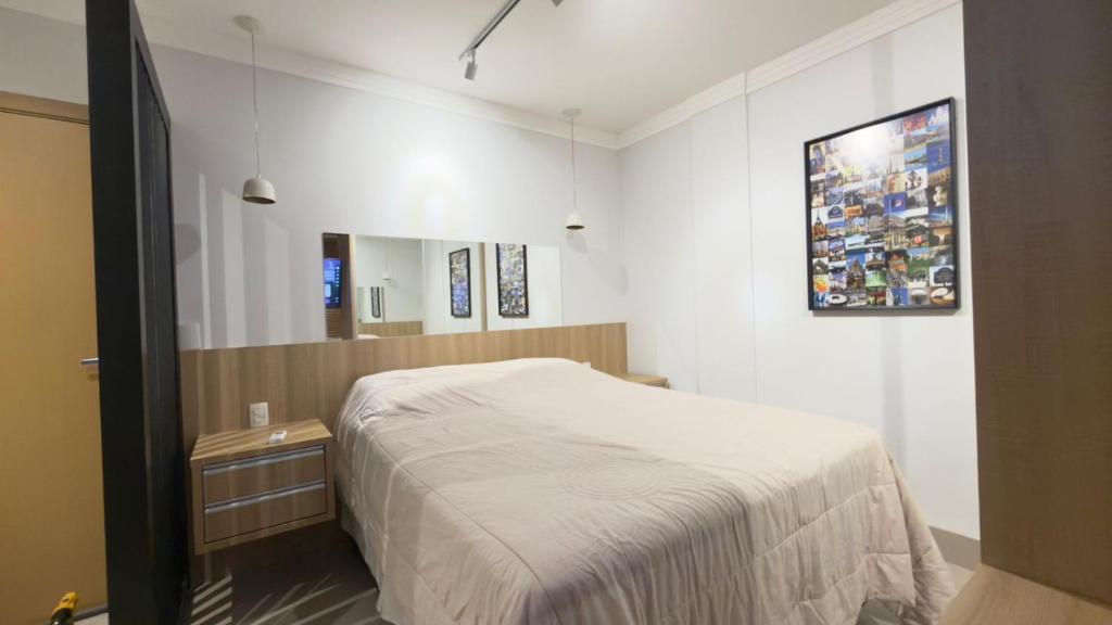 Un dormitorio pequeño con una cama y un espejo. en Studio Inn Rami, en Uberlândia