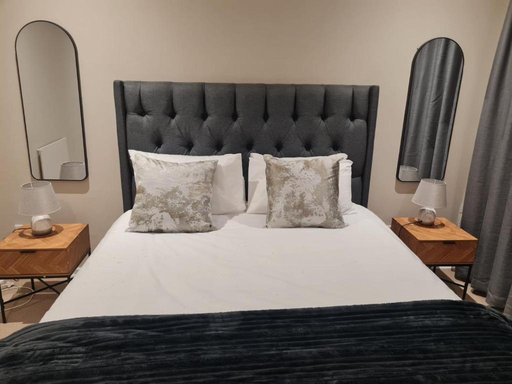 a bedroom with a large bed with a black headboard at 1 Bedroom Luxury Apartment, Beacon Bay North, East London in East London