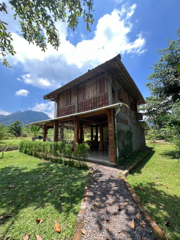 una gran casa de madera en un campo de hierba en Pondok Sitinggil Muncul, en Muncul