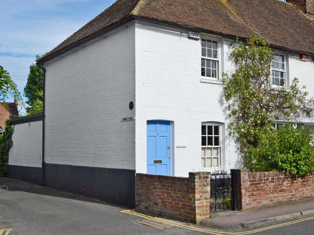 a white house with a blue door on a street at Owl Cottage in Fordwich