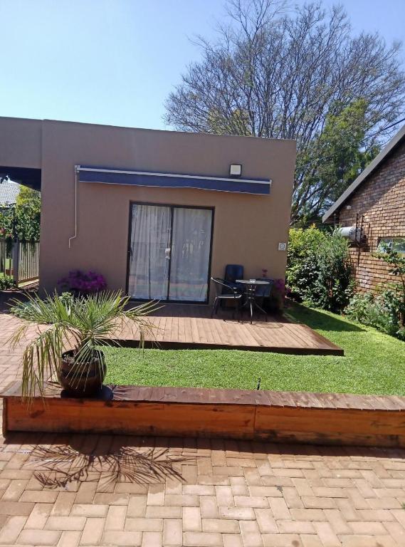 a house with a wooden deck and a patio at Hoovers Nest in Pretoria