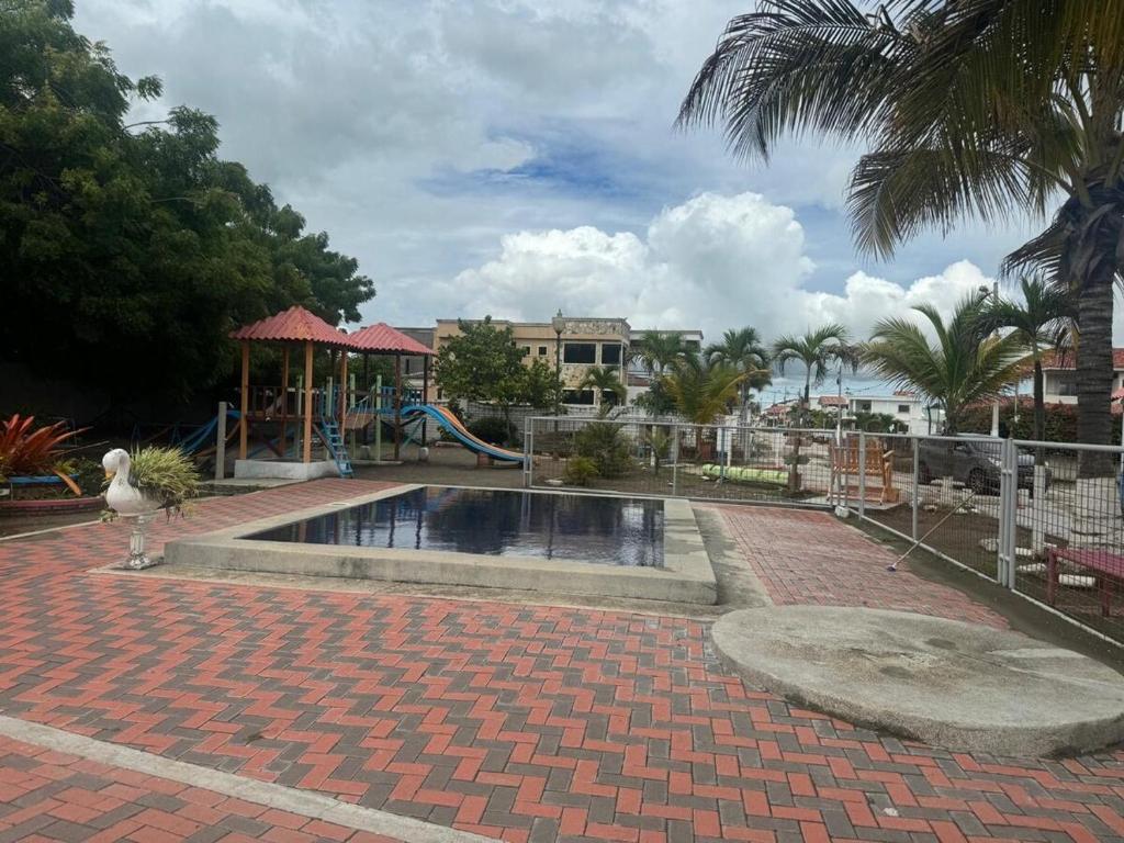 プラヤスにあるCasa en urbanización privada a 2 minutos caminando de la playa, Vía a Dataの公園内の遊び場付きスイミングプール