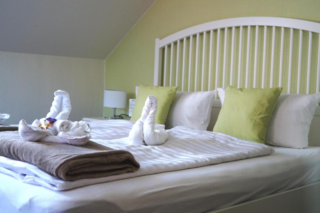 a bed with two stuffed animals on top of it at REGIOHOTEL Pfälzer Hof Wernigerode in Wernigerode