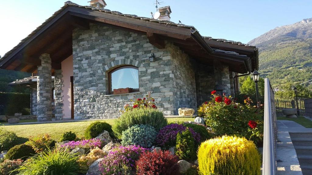 una casa in pietra con un giardino di fronte di Appartamento Fleur Des Neiges ad Aosta