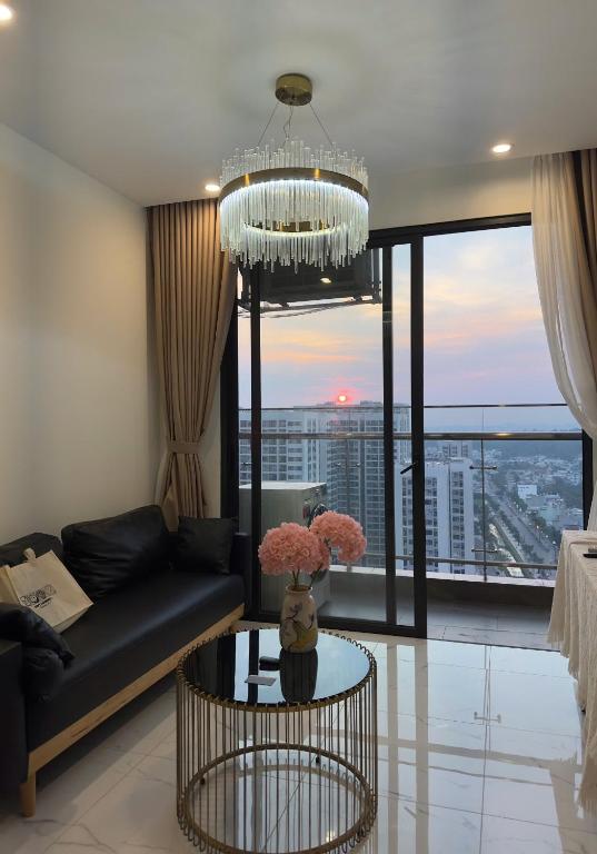 a living room with a couch and a chandelier at BigSummer House in Long Bình