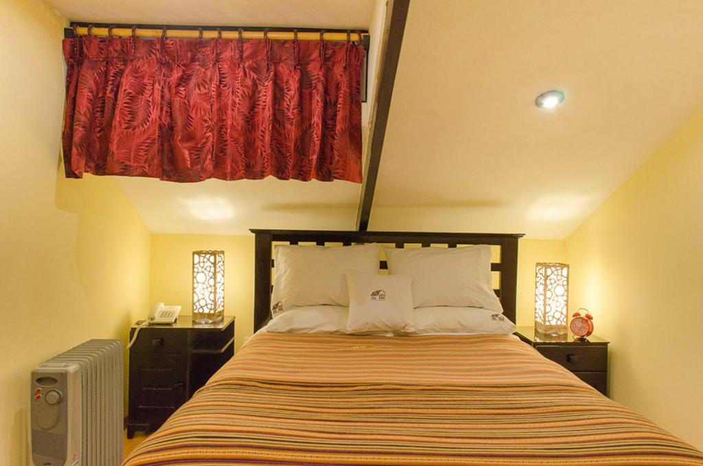 una camera da letto con un grande letto con una tenda rossa di Cusco Bed and Breakfast a Cuzco