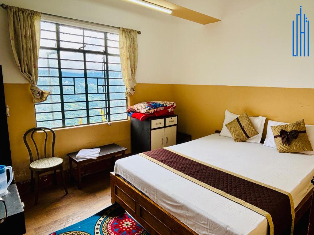 a bedroom with a large bed and a window at Dhanishta Delight in Gangtok