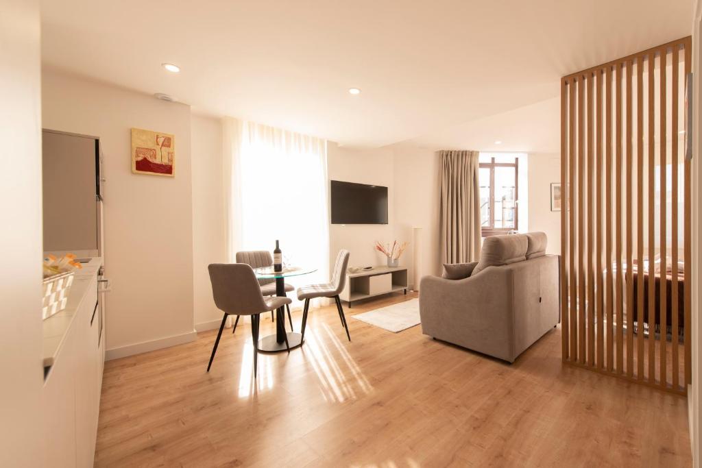 ein Wohnzimmer mit Tisch und Couch in der Unterkunft ALAIA ROOMS, Apartamentos Turísticos 0003 in Logroño