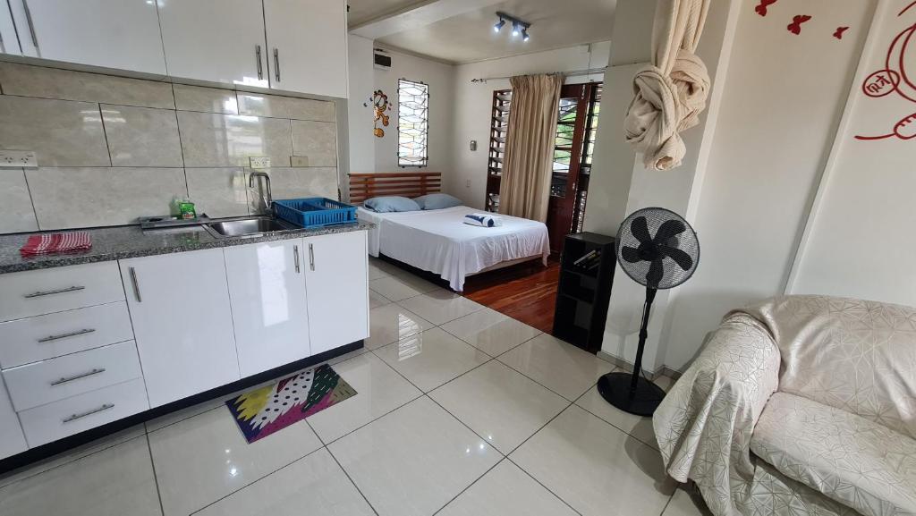 a kitchen and a bedroom with a bed in a room at Cozy Studio Apt Pool Free WIFI in Suva