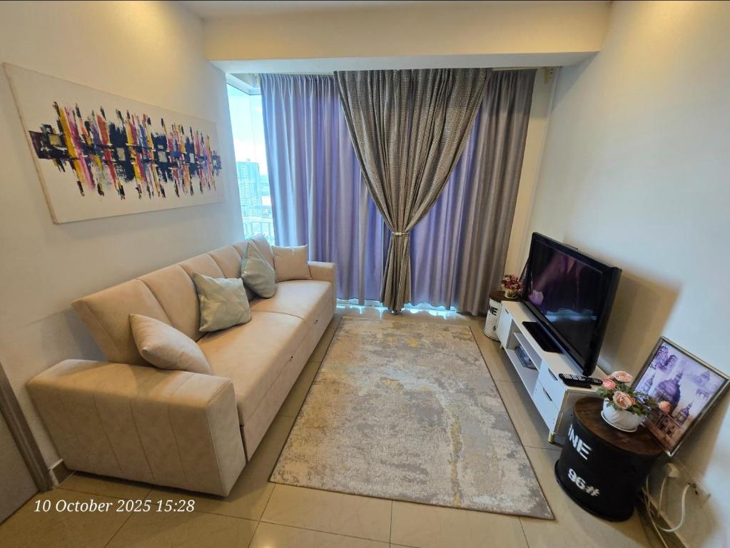a living room with a couch and a television at HOMESTAY SUITE MENARA U2 , MSU , SEKSYEN 13 SHAH ALAM, Selangor in Shah Alam