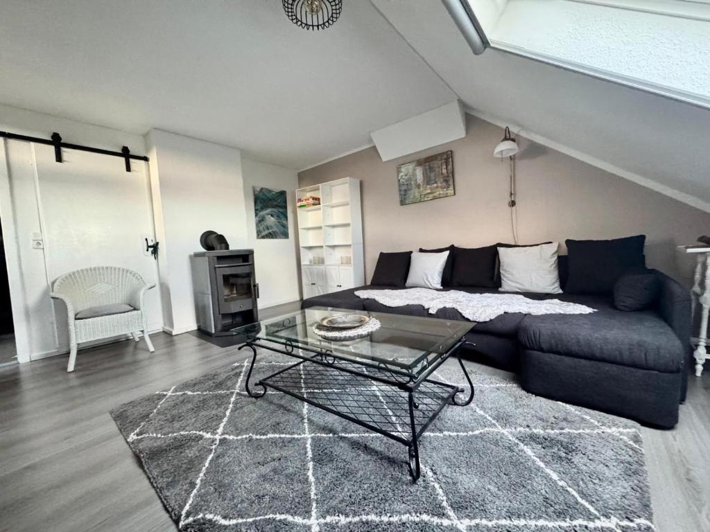 a living room with a couch and a glass table at Vierseitenhof Hasenfelde - Ferienwohnung Feldblick in Steinhöfel