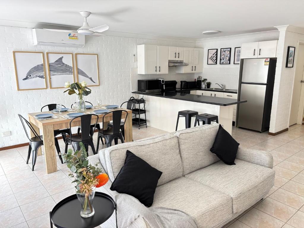 een woonkamer en keuken met een bank en een tafel bij Catalina Cove-From Door to Shore in 2 Minutes in Shoal Bay