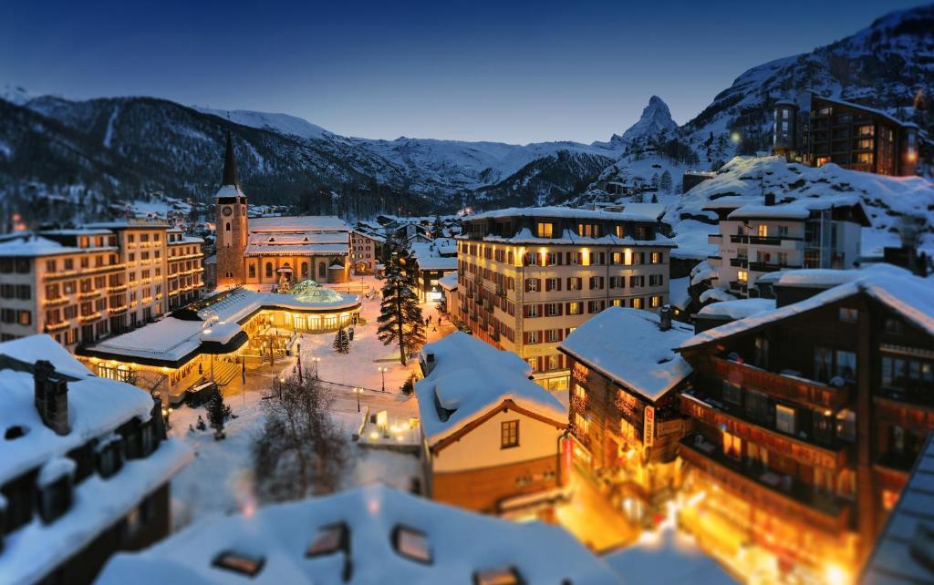 a view of a city with snow covered buildings at Monte Rosa Boutique Hotel in Zermatt